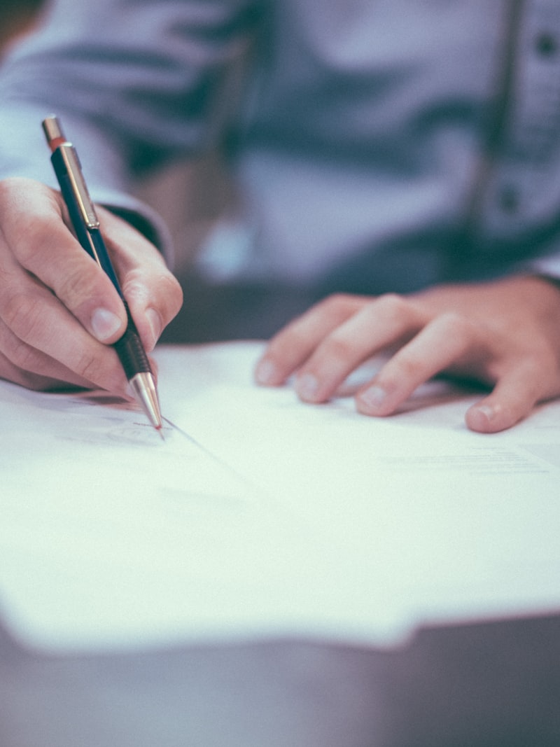 Mano firmando un documento con pluma estilográfica.